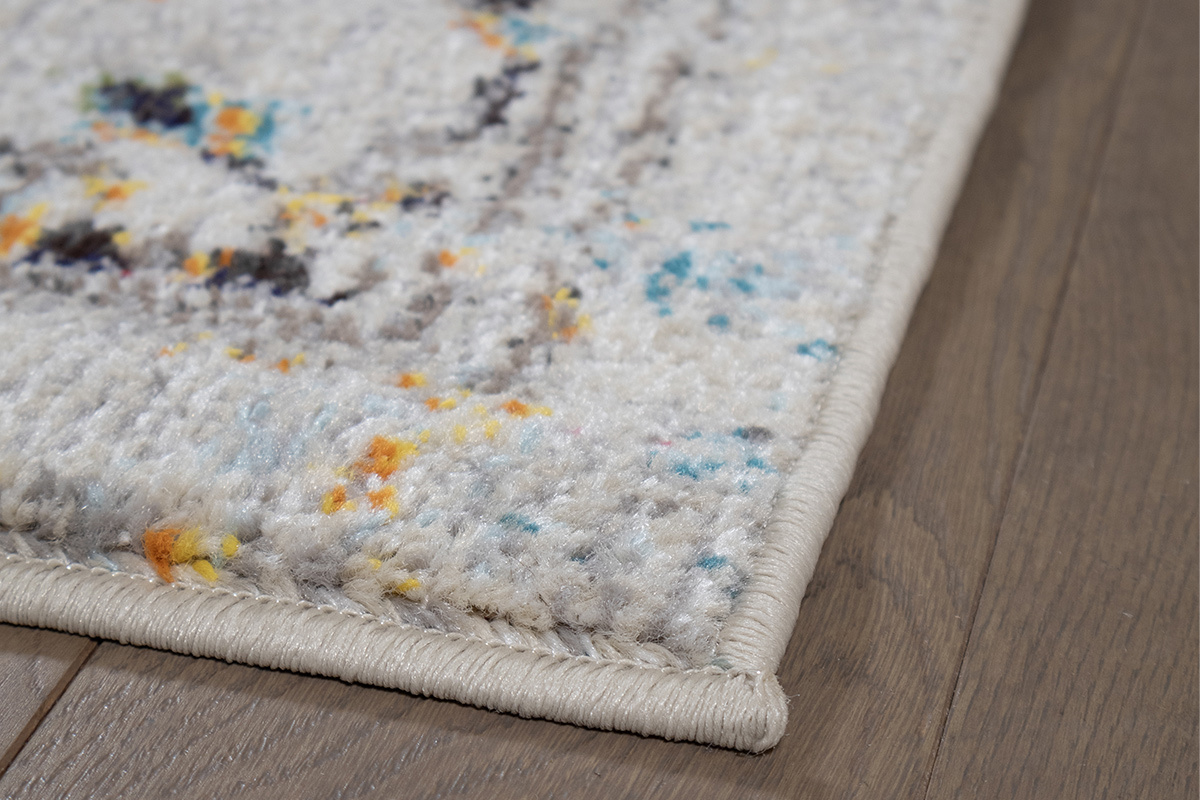 Alfombra rectangular DULCE multicolor, vista en primer plano del patr�n y borde sobre suelo de madera.