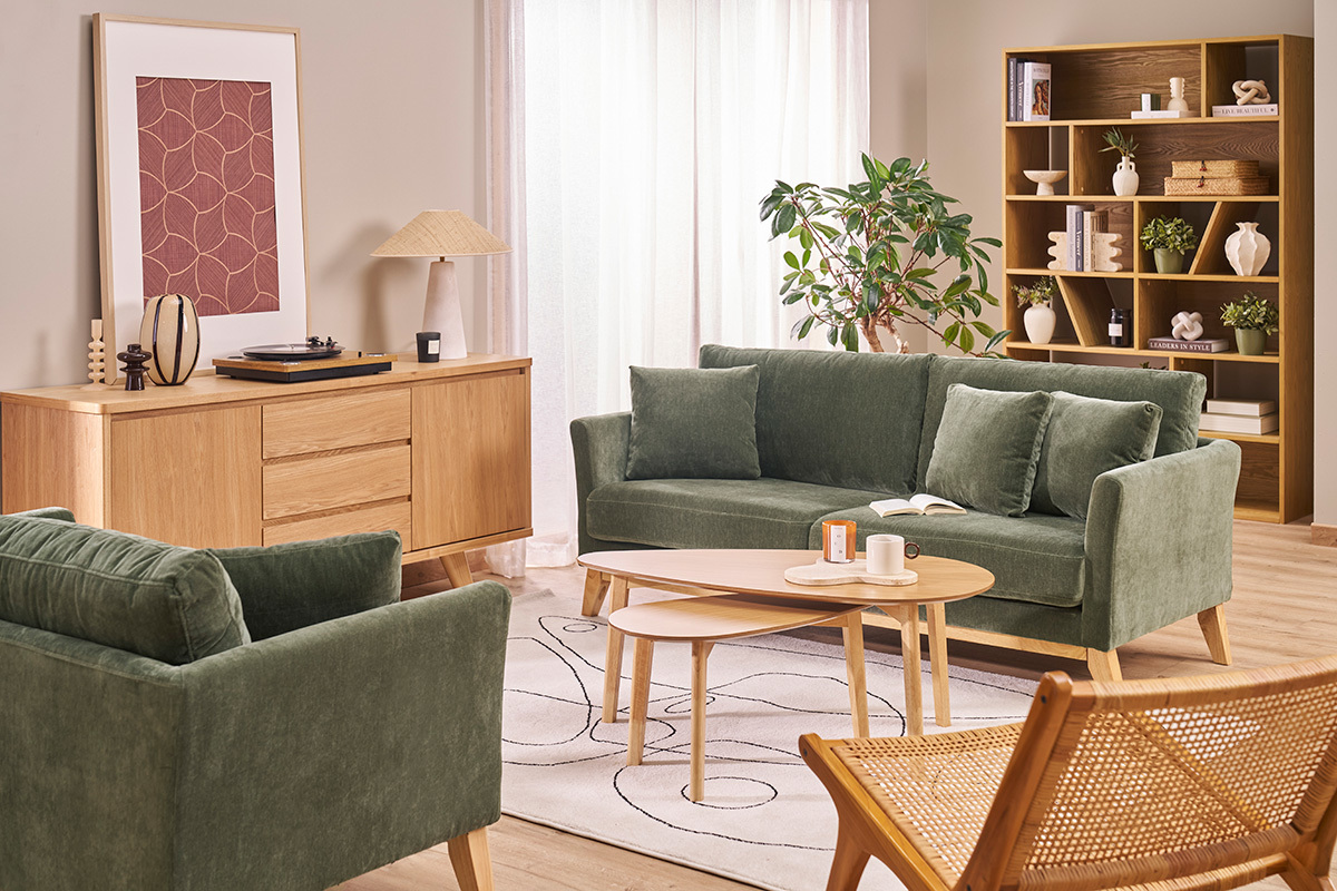 Buffet escandinavo de madera clara con dos puertas y tres cajones en una sala de estar con sof� verde y mesa baja.