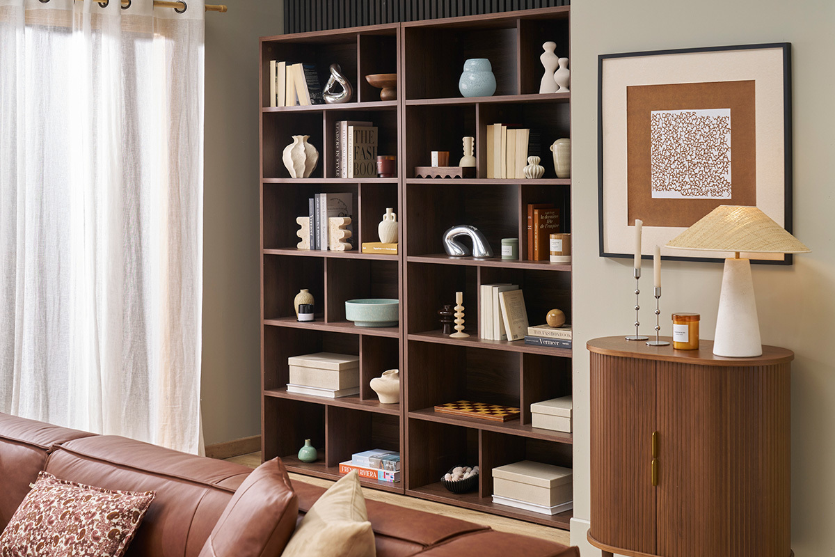 Biblioteca de nogal oscuro con 12 compartimentos, libros y decoraciones, vista interior.