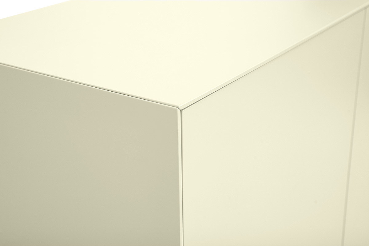 Esquina superior de un aparador alto beige con acabado mate visto de cerca.