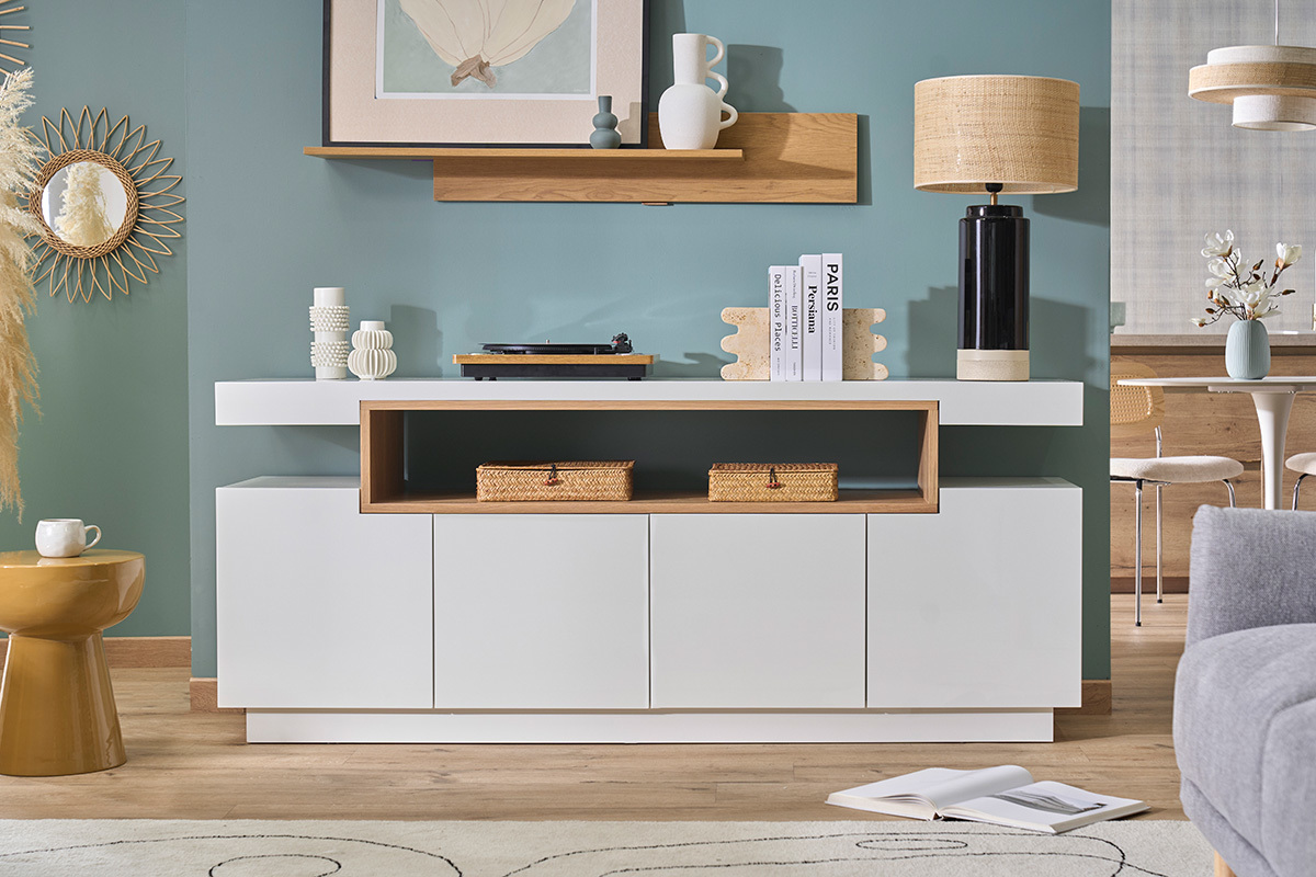 Buffet escandinavo blanco lacado brillante y madera de 4 puertas, vista frontal sobre fondo azul.