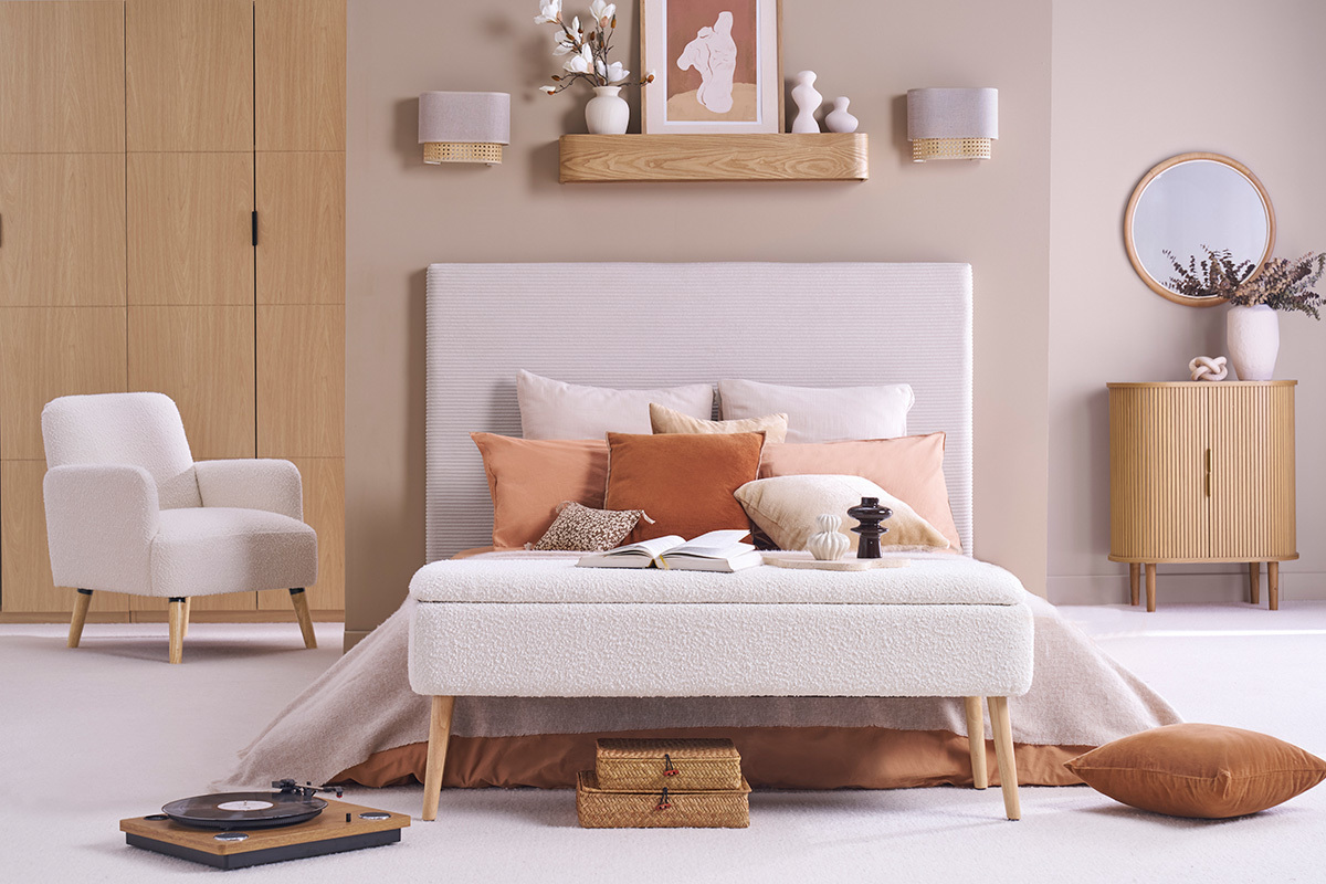 Cabecero de terciopelo beige YOLANDA, vista frontal, con cojines beige y naranja.