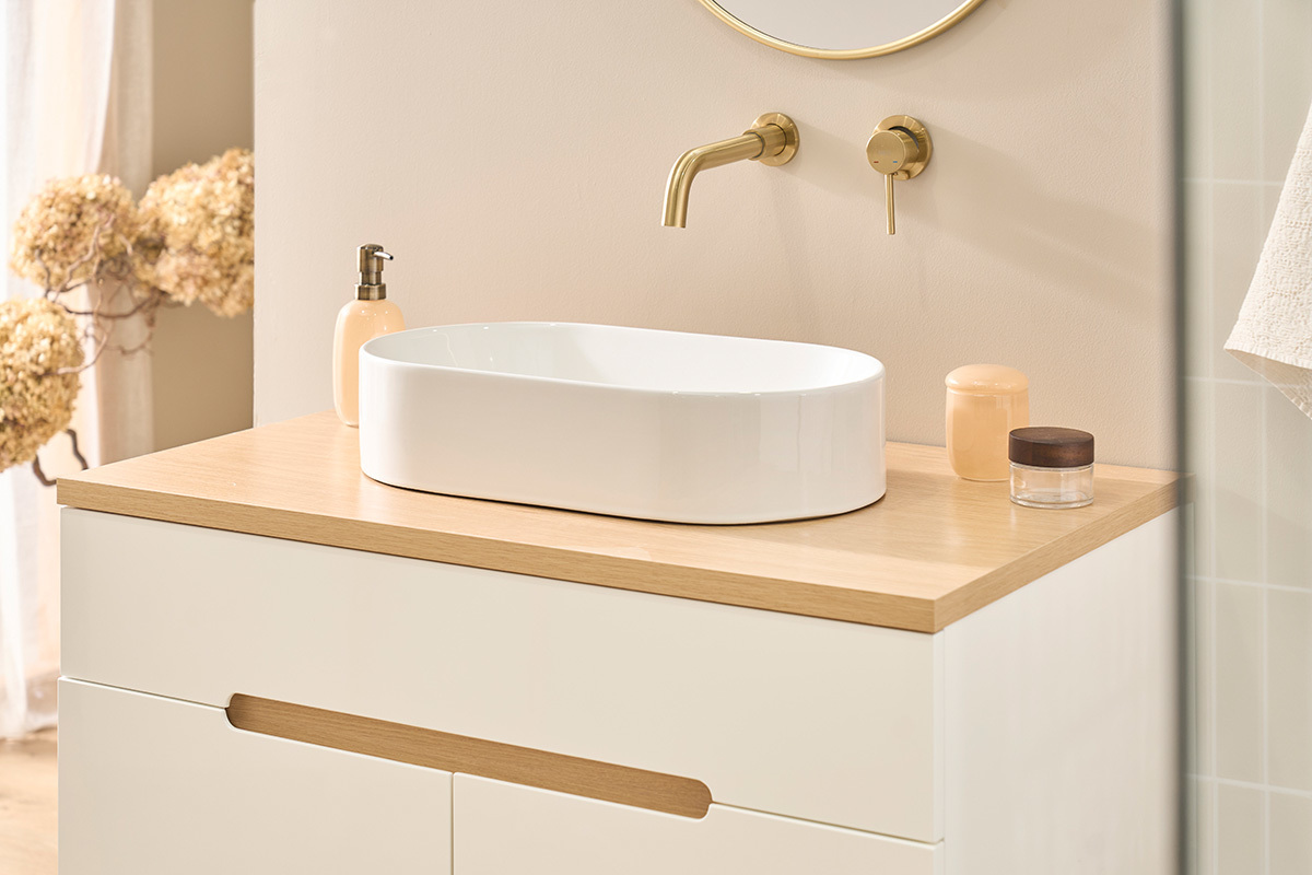 Lavabo ovalado de cer�mica blanca sobre mueble de madera, vista lateral