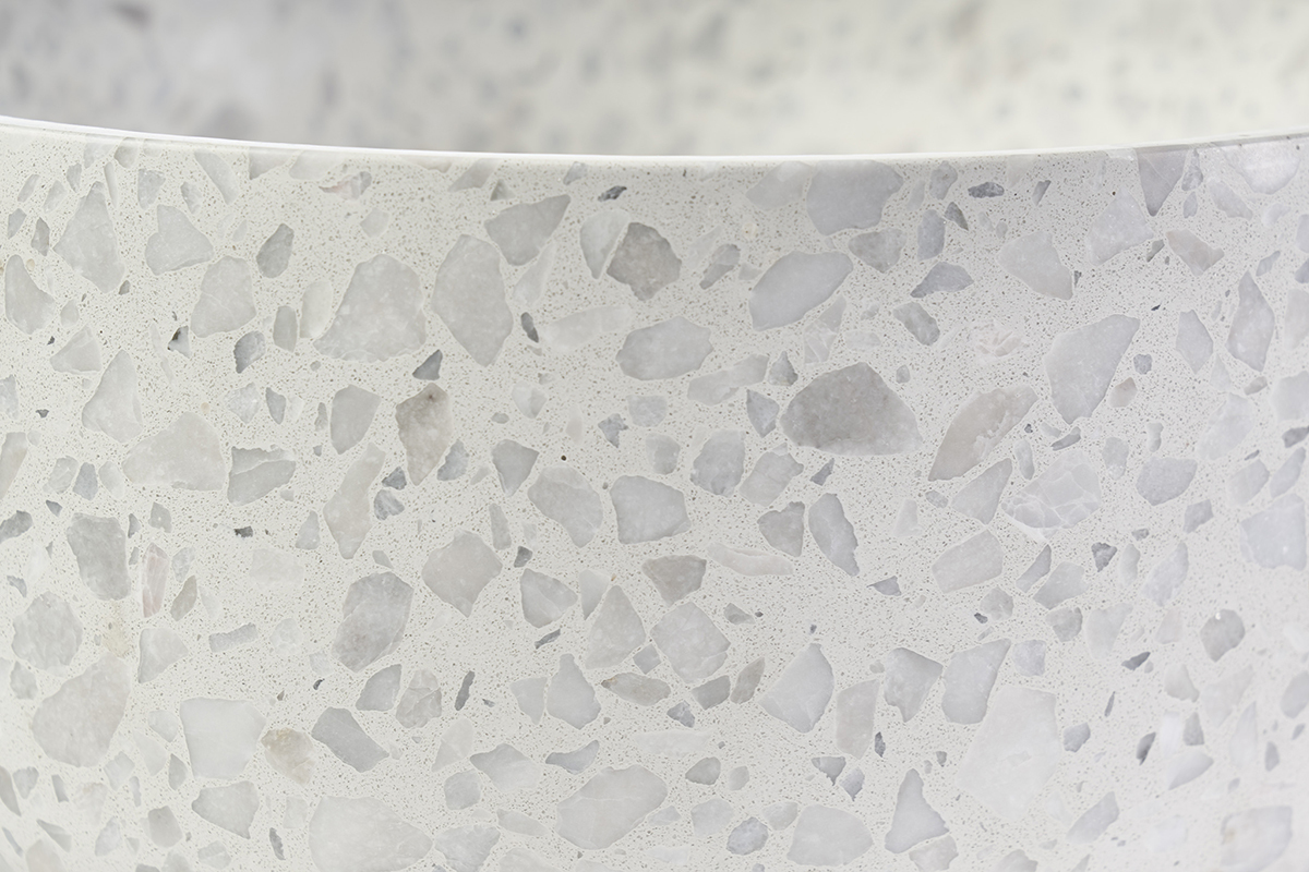 Lavabo redondo de terrazo gris, vista cercana de los detalles minerales y texturas