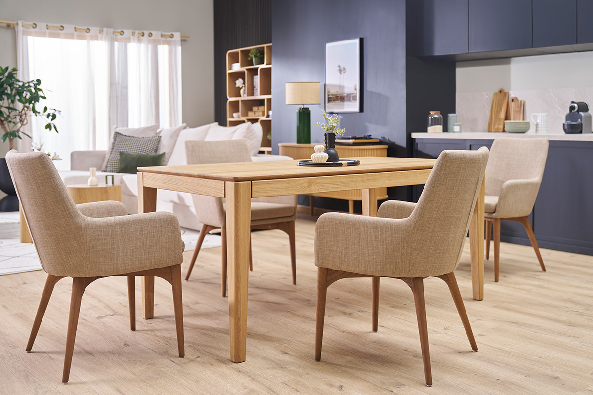 Sillas de tela beige y madera oscura alrededor de una mesa en un sal�n moderno.