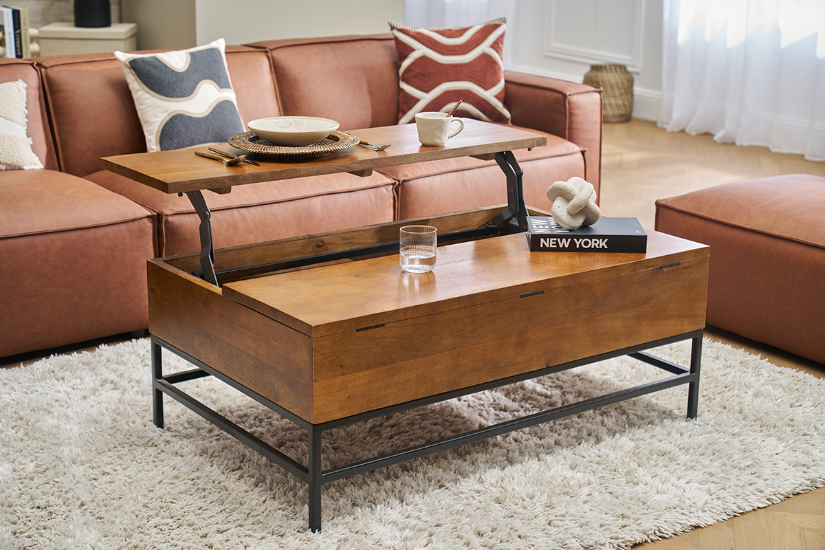 Mesa baja YPSTER de madera de mango y metal negro con bandeja elevable, en un saln con sof.