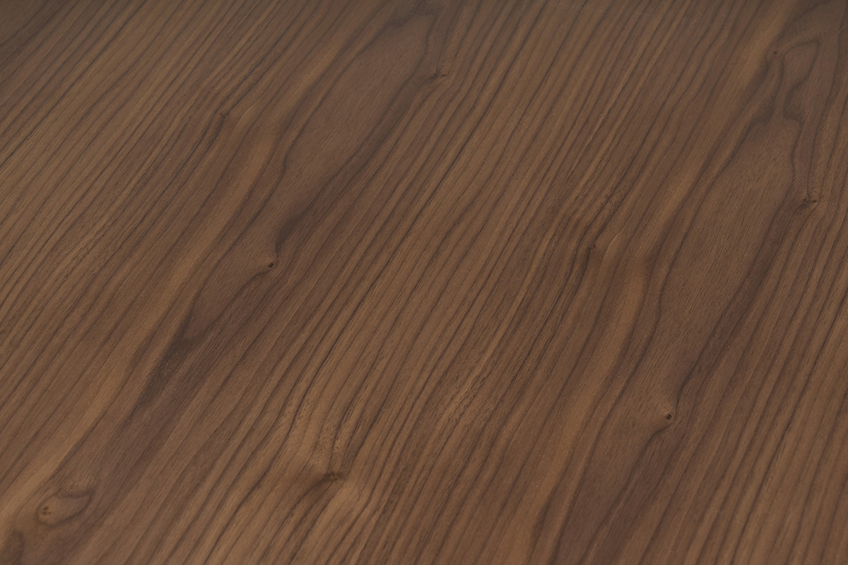 Superficie de la mesa de centro rectangular en madera oscura de nogal, vista cercana.