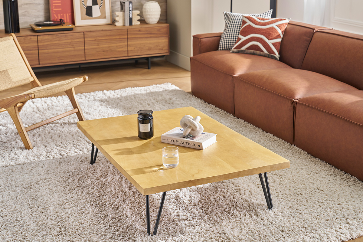 Mesa baja VIBES de madera de mango y metal, vista de tres cuartos, en un saln con sof y silln.