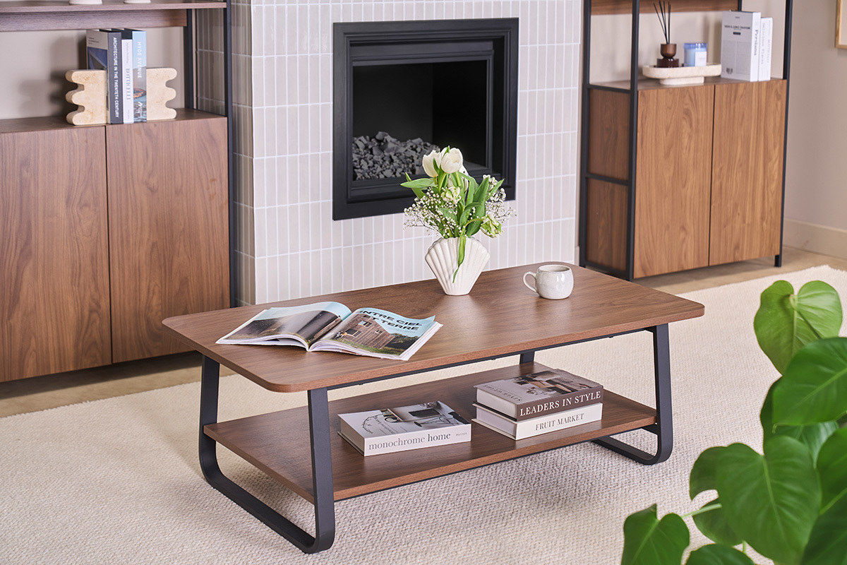 Mesa baja rectangular de madera de nogal y metal con revistas y jarr�n, vista desde arriba.