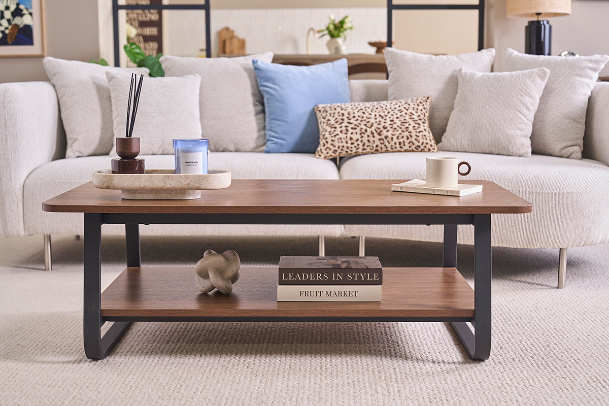 Mesa de centro rectangular de madera de nogal y metal con estante inferior, vista frontal junto a un sof�.