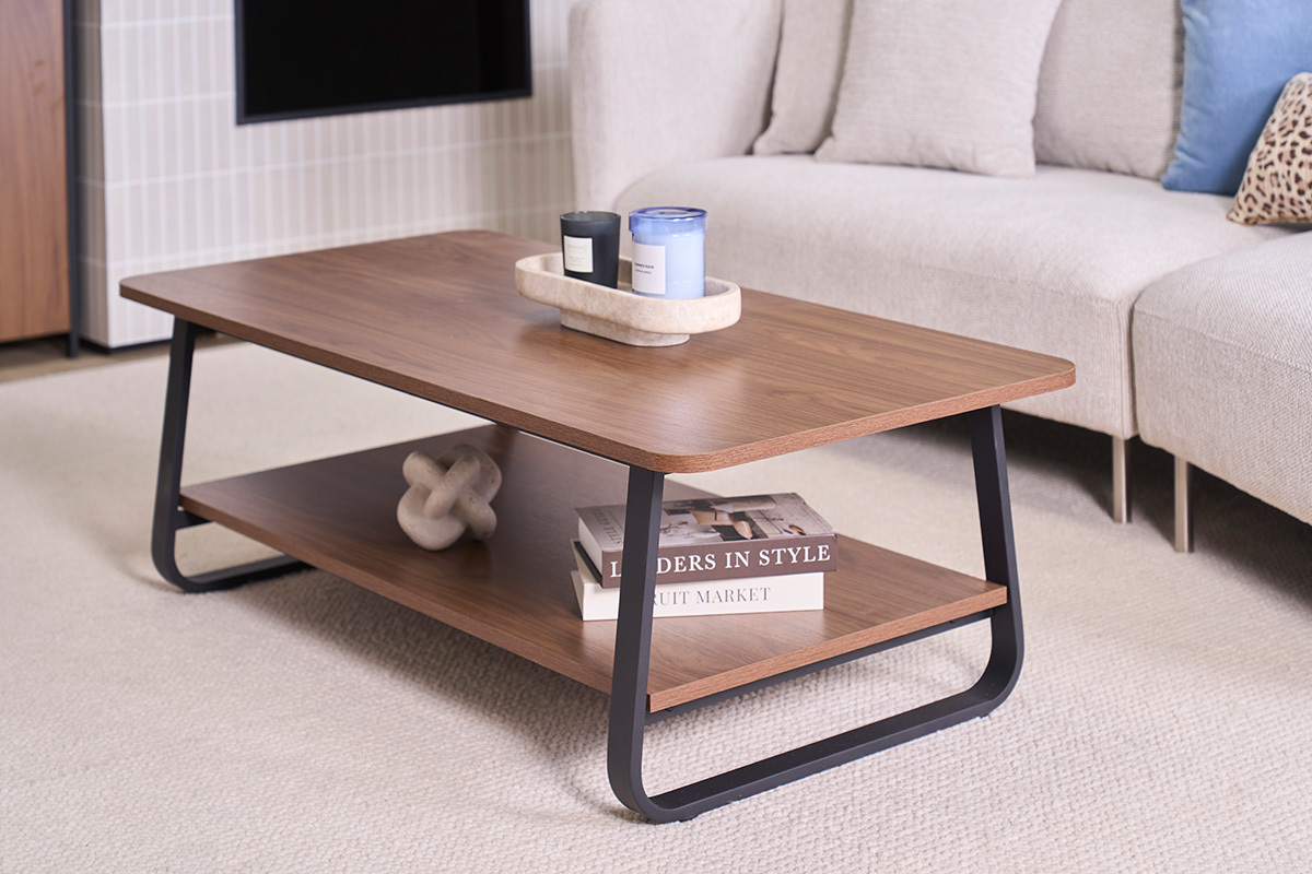 Mesa de centro rectangular de madera de nogal y metal, vista frontal con objetos decorativos.