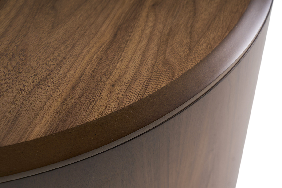 Detalle de la mesa baja ZAHRA en madera oscura nogal, vista desde arriba mostrando el tablero curvado.