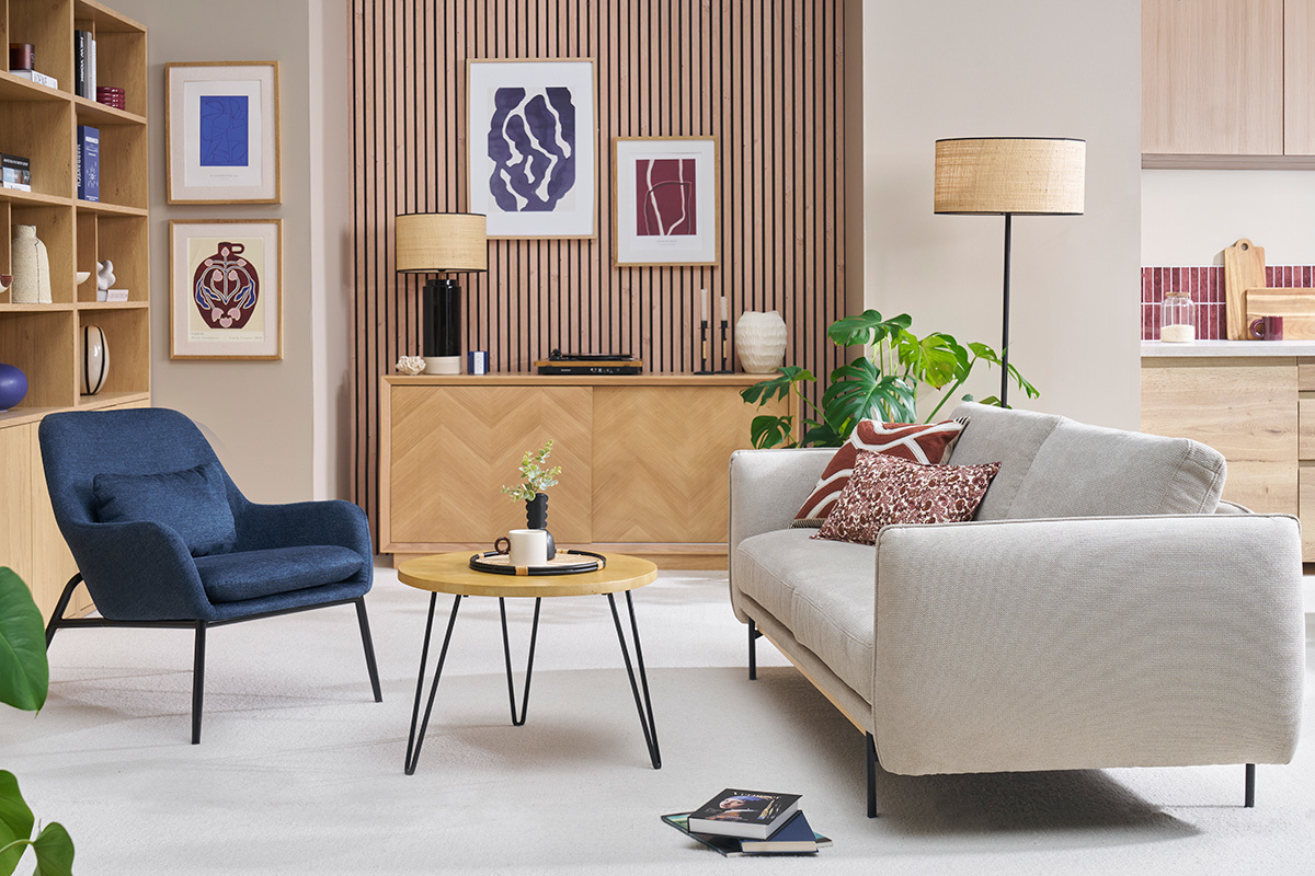 Mesa baja redonda de madera de mango y metal, vista de sal�n con sof� y sill�n.