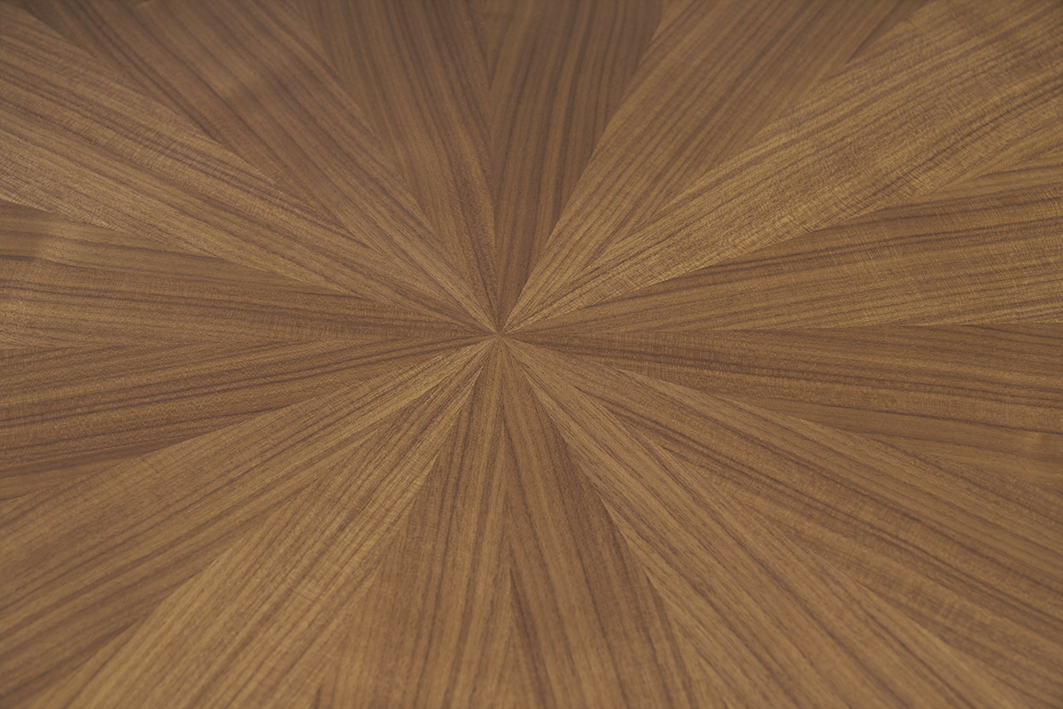 Bandeja de mesa redonda con chapa de nogal con patrn de sol vista de cerca.