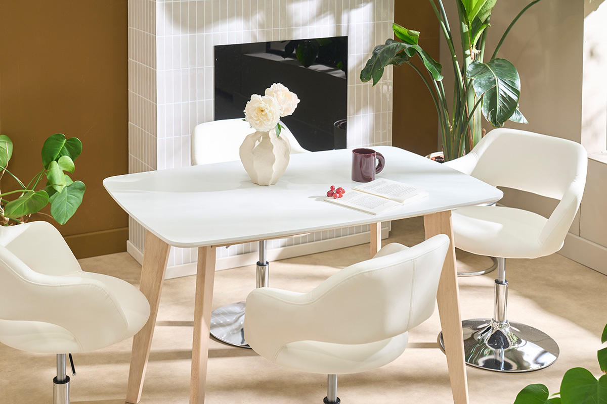 Mesa de comedor de dise�o blanca con madera clara, vista desde arriba, rodeada de sillas blancas.