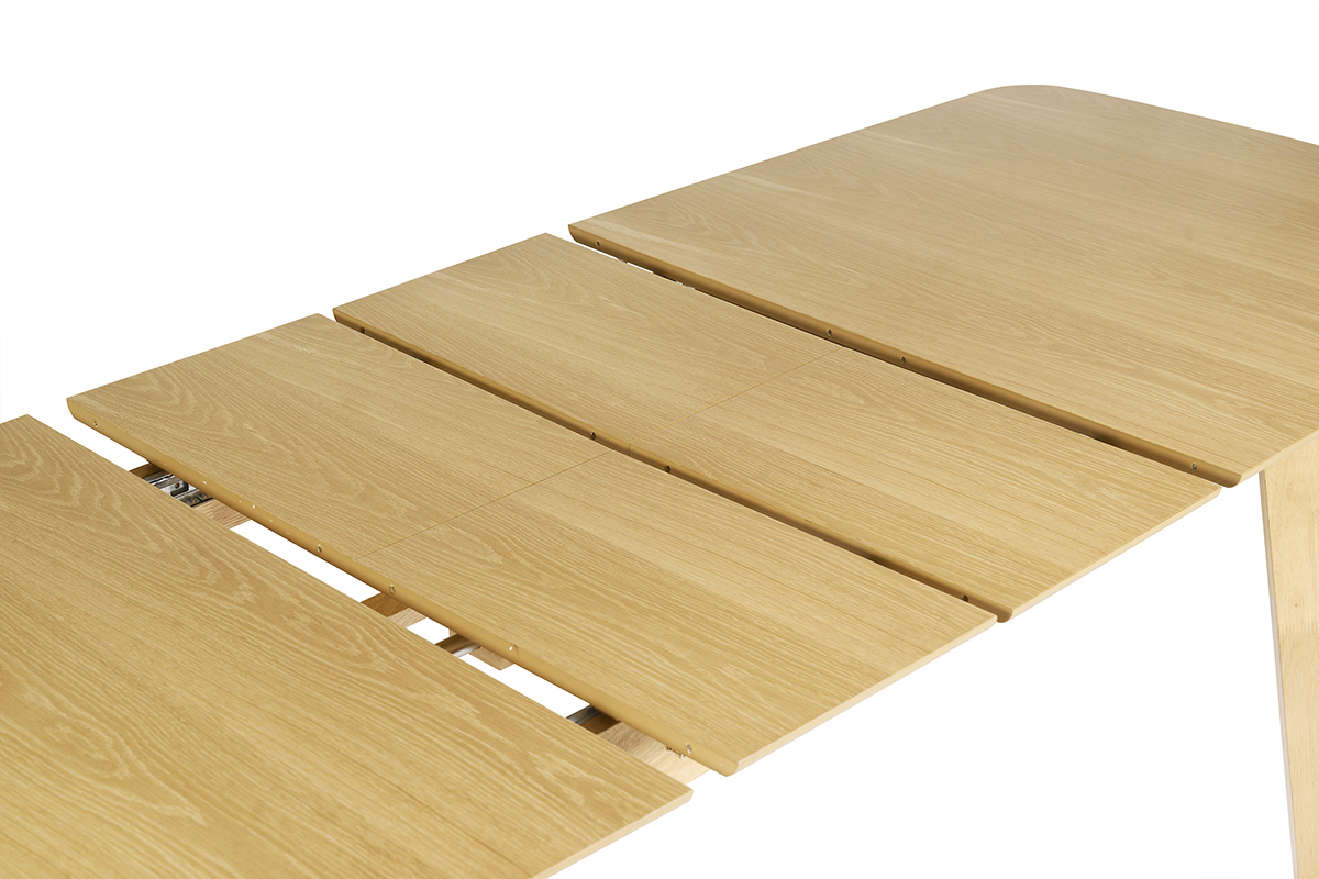 Mesa de comedor extensible de madera clara con extensiones visibles, vista desde arriba.