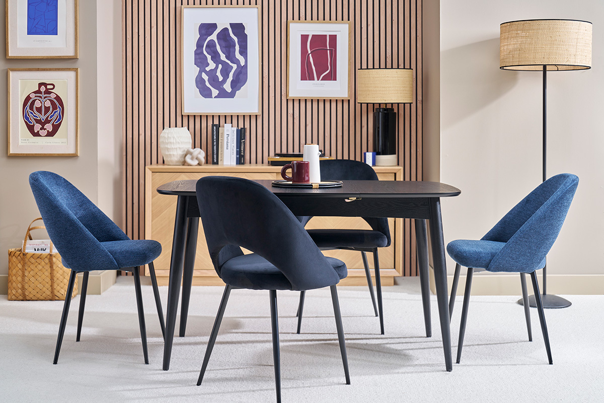 Mesa de comedor extensible cuadrada de madera negra con cuatro sillas azules, vista lateral.