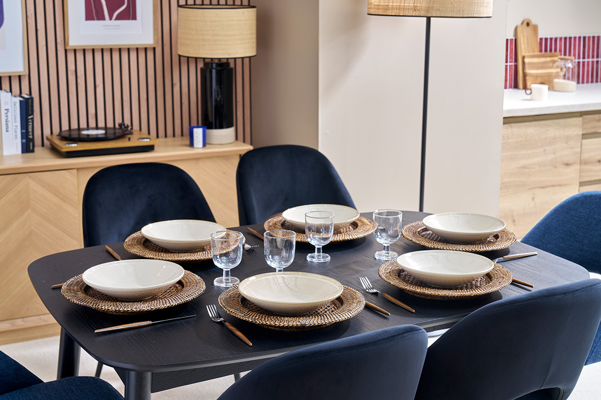 Mesa de comedor negra NORDECO con platos y vasos, vista desde arriba.