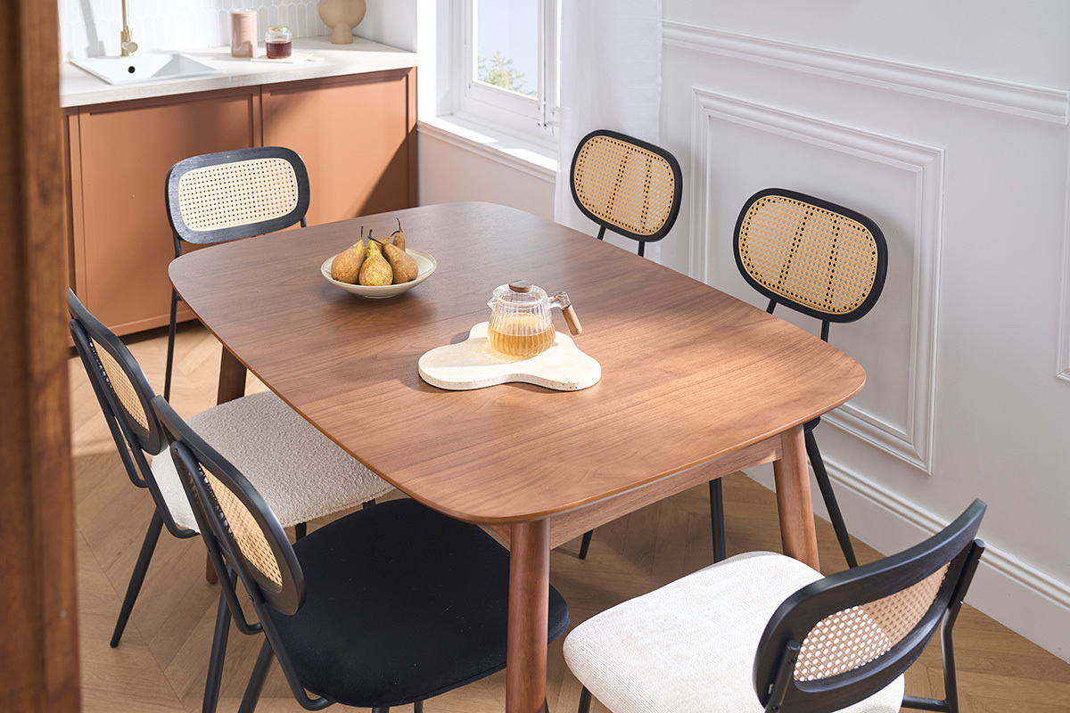 Mesa de comedor extensible NORDECO en nogal, vista en tres cuartos con sillas y frutas sobre la mesa.
