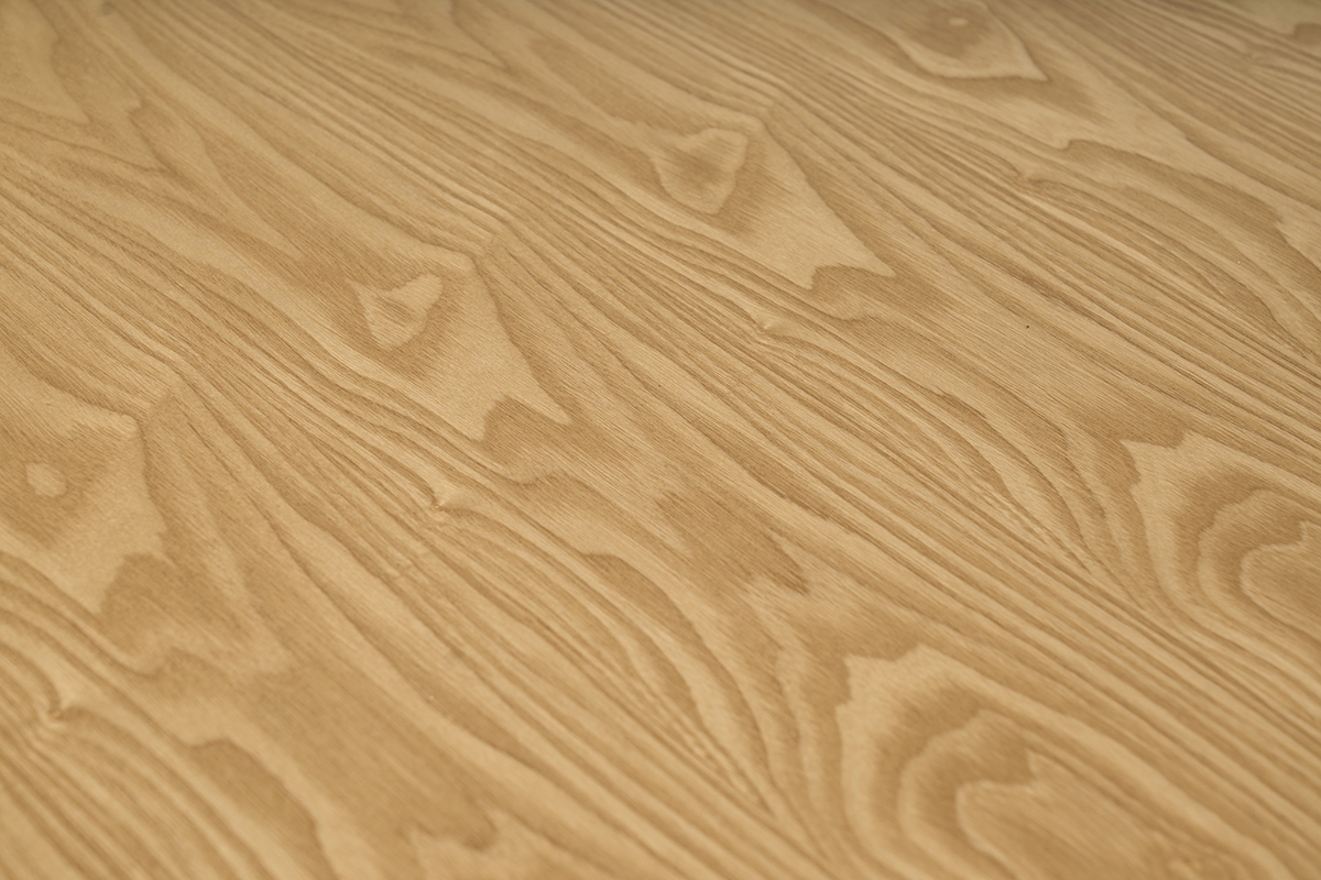 Tablero de la mesa de comedor extensible CLAUDIE en madera clara de fresno, vista cercana.