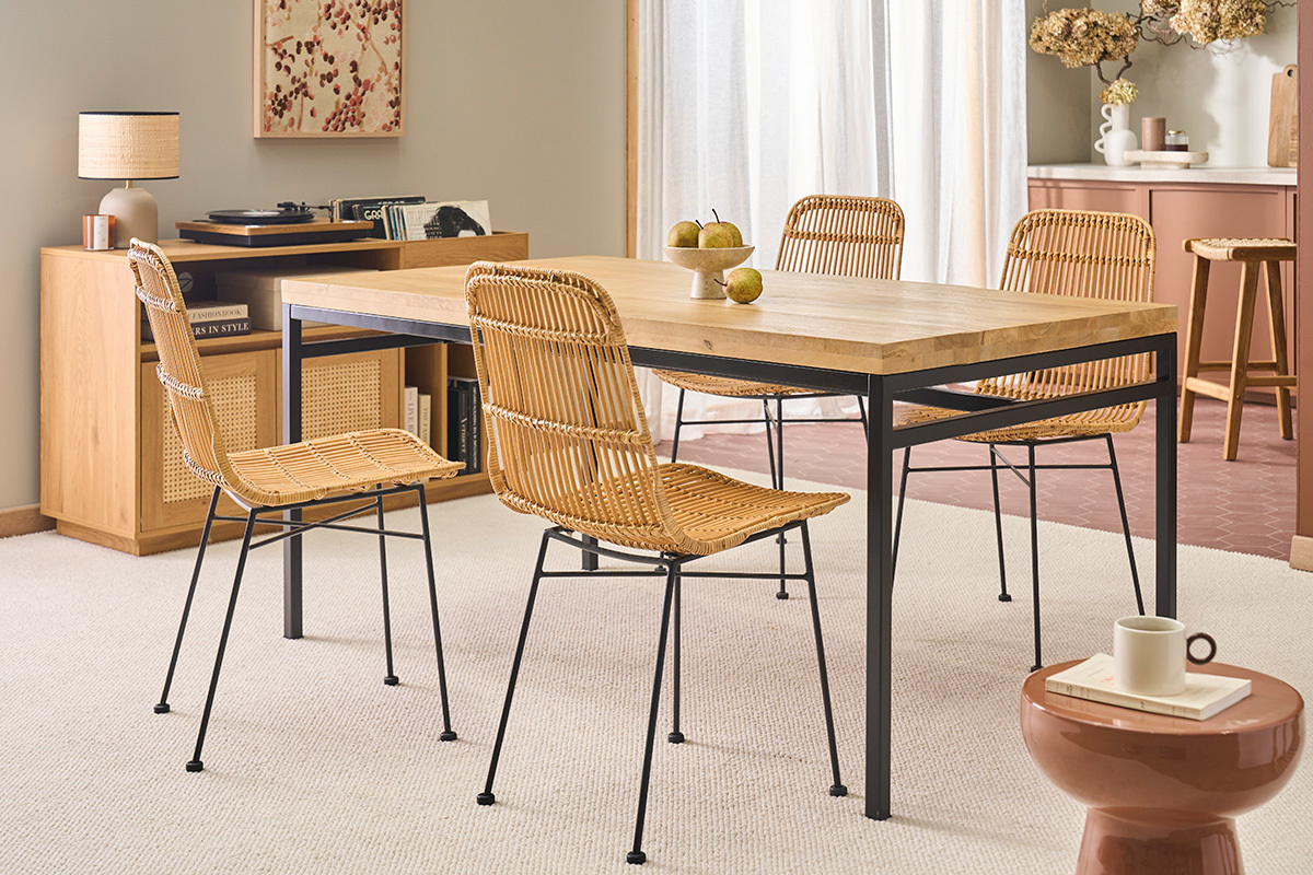 Mesa de comedor de madera y metal con sillas de rat�n en un comedor.