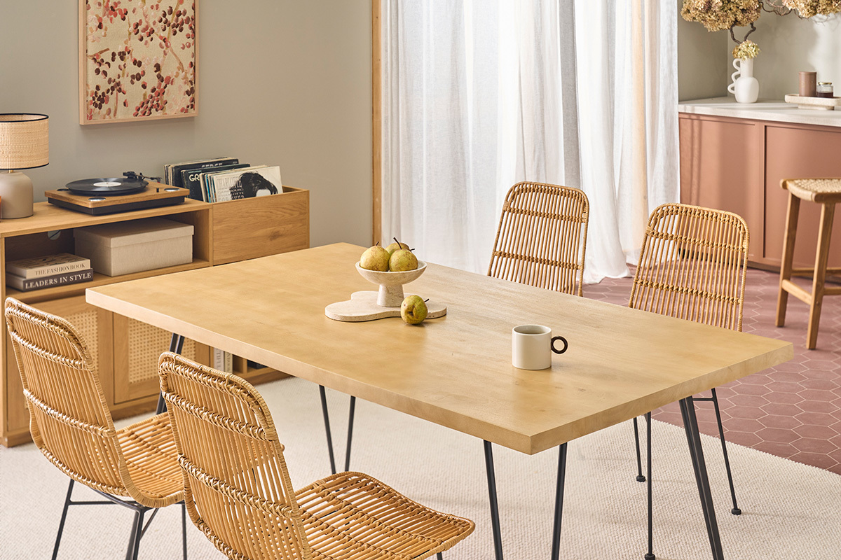 Mesa de madera clara con 4 sillas de rat�n y patas de metal, vista en �ngulo.