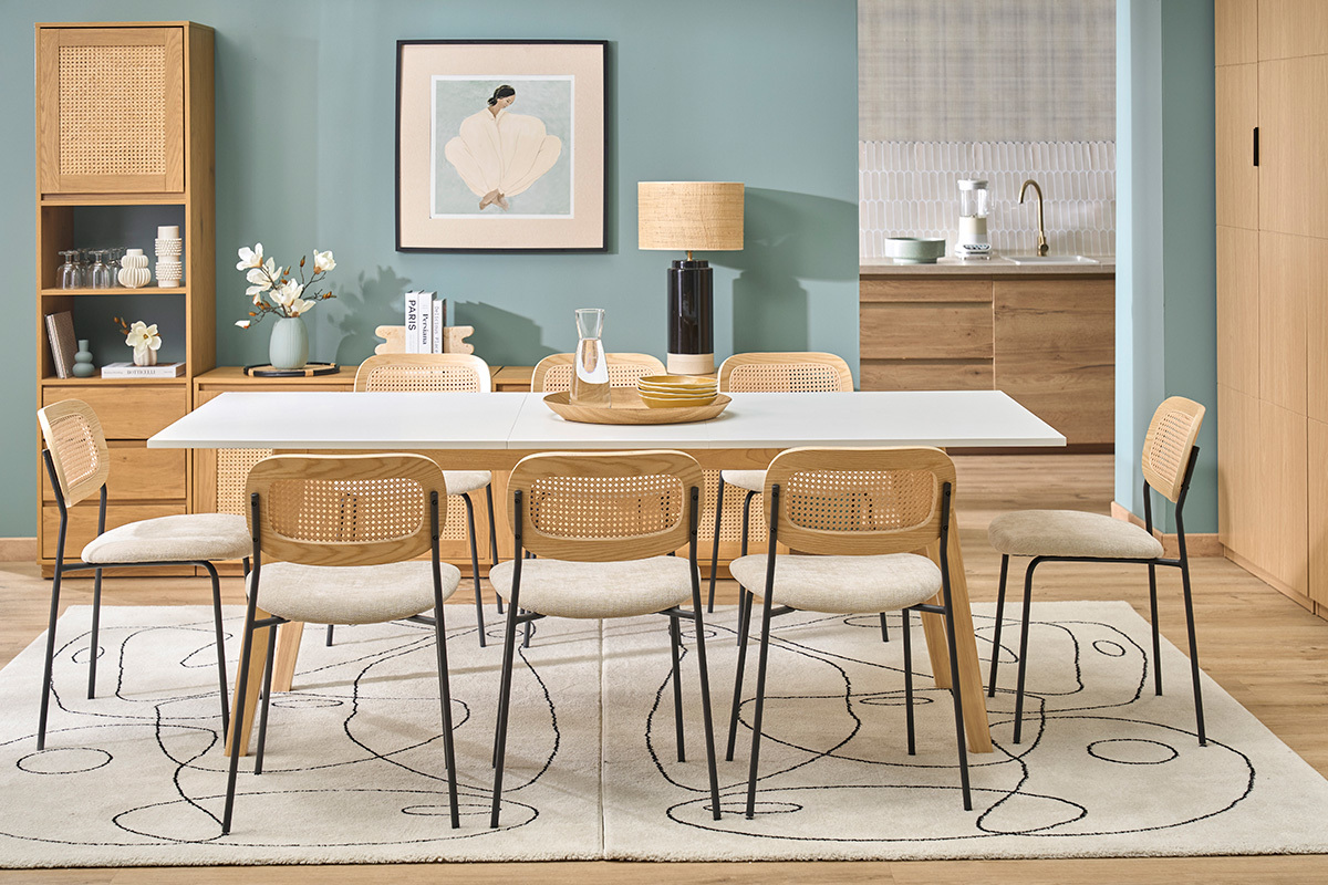 Mesa extensible rectangular blanca y de madera clara con sillas alrededor, vista general en un interior moderno.