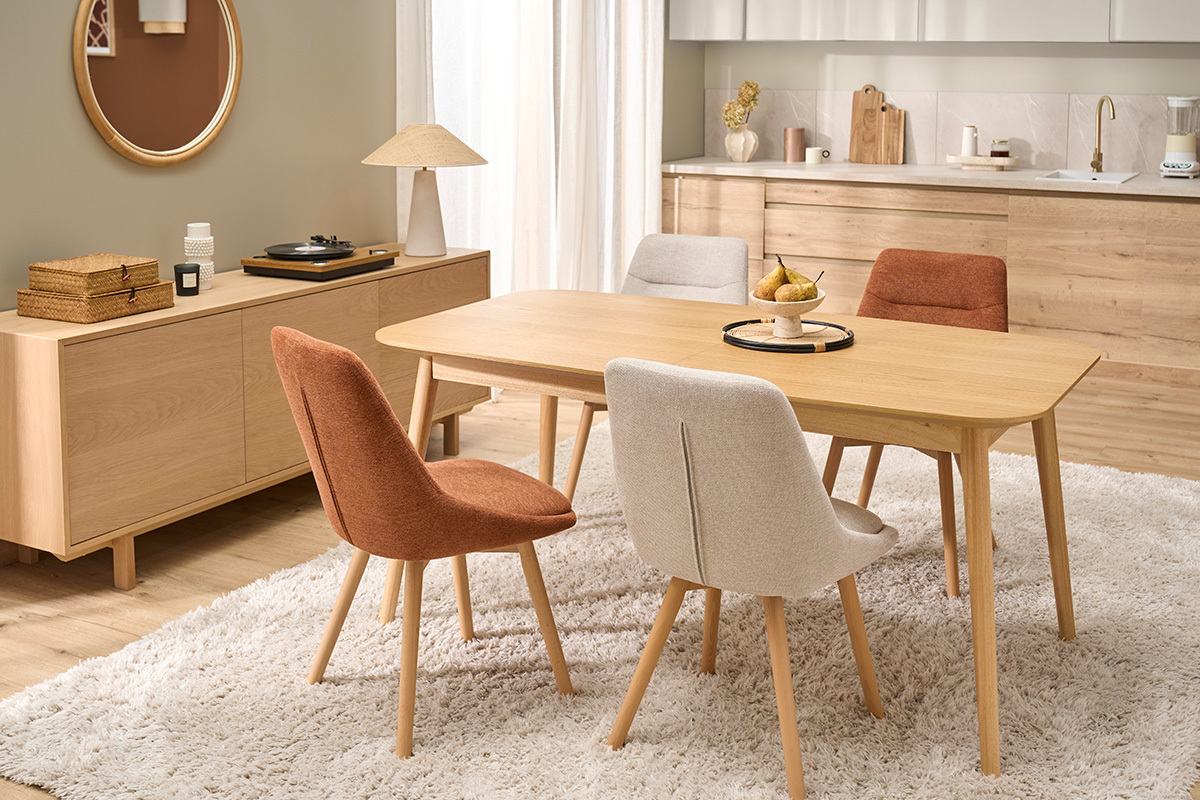 Mesa extensible rectangular de madera con sillas coloridas en un comedor moderno.