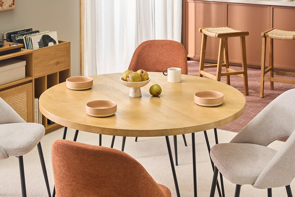 Mesa redonda de mango con platos, sillas y decoraci�n de cocina.