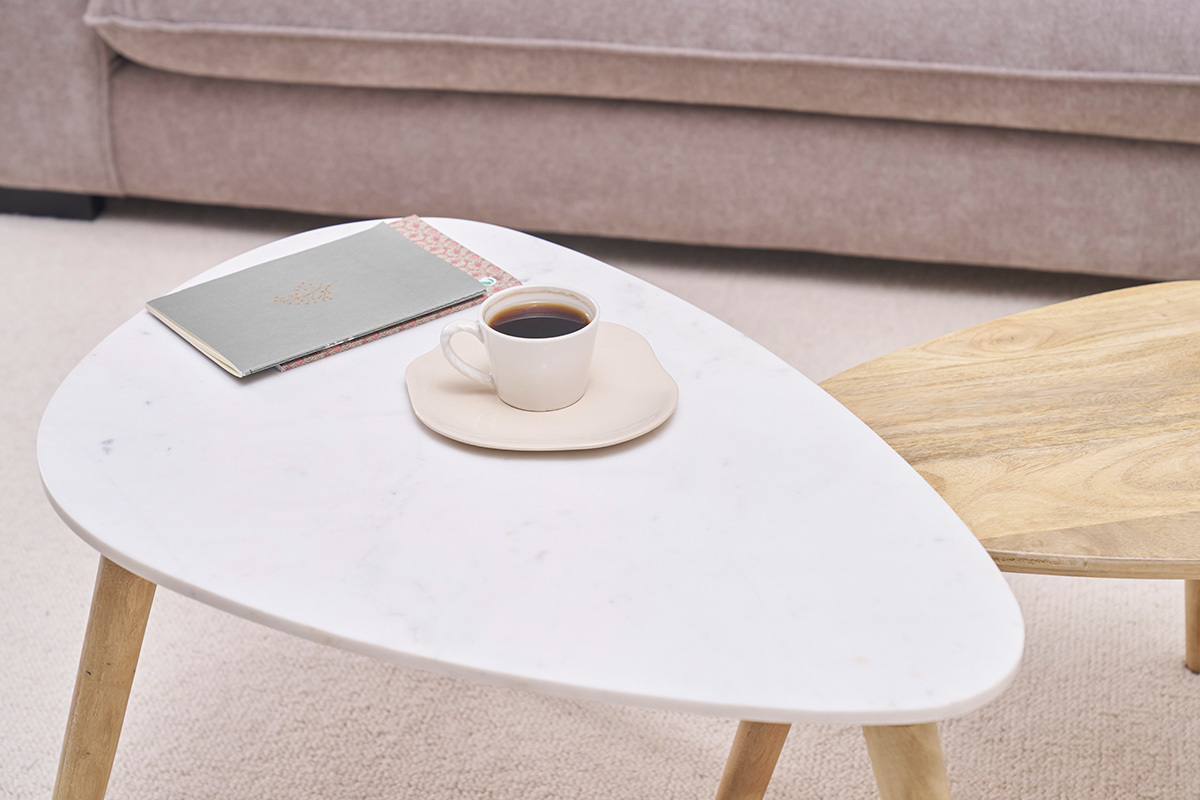 Mesas bajas nido de madera y m�rmol, con taza y cuaderno.