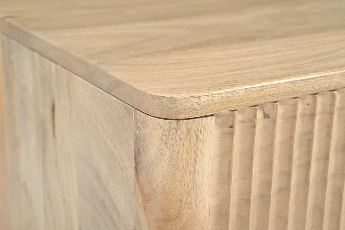 Detalle de la esquina de una mesita de noche de madera clara de mango, mostrando el acabado y las l�neas.