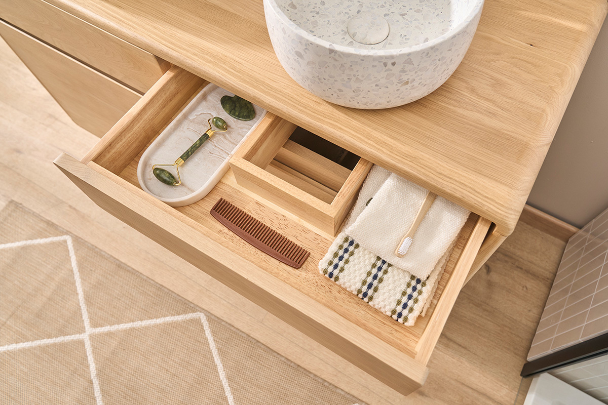 Caj�n abierto del mueble de ba�o ESTEBAN en madera de roble macizo, con accesorios de ba�o.
