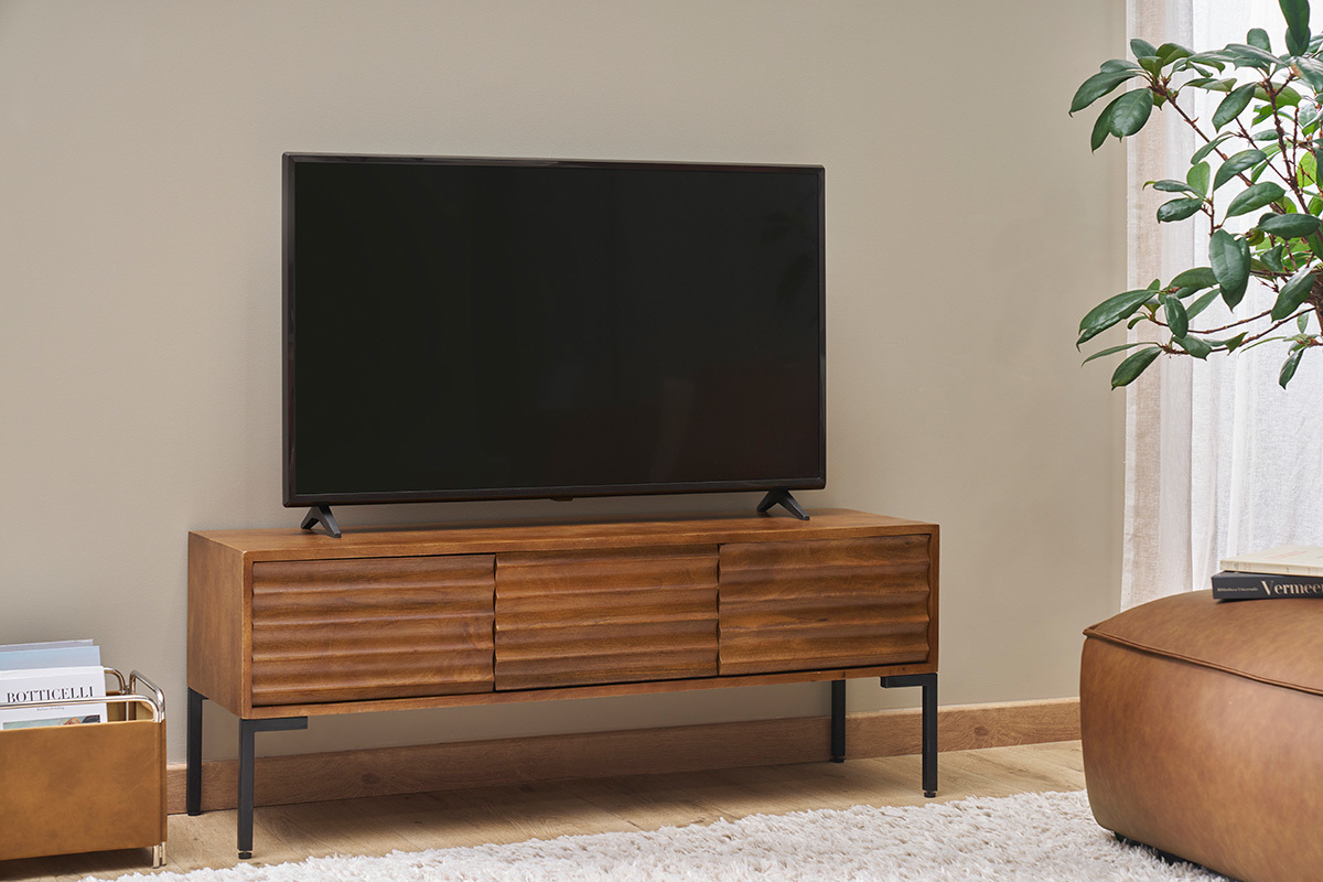 Mueble de TV de madera de mango macizo con tres puertas, colocado debajo de un televisor.