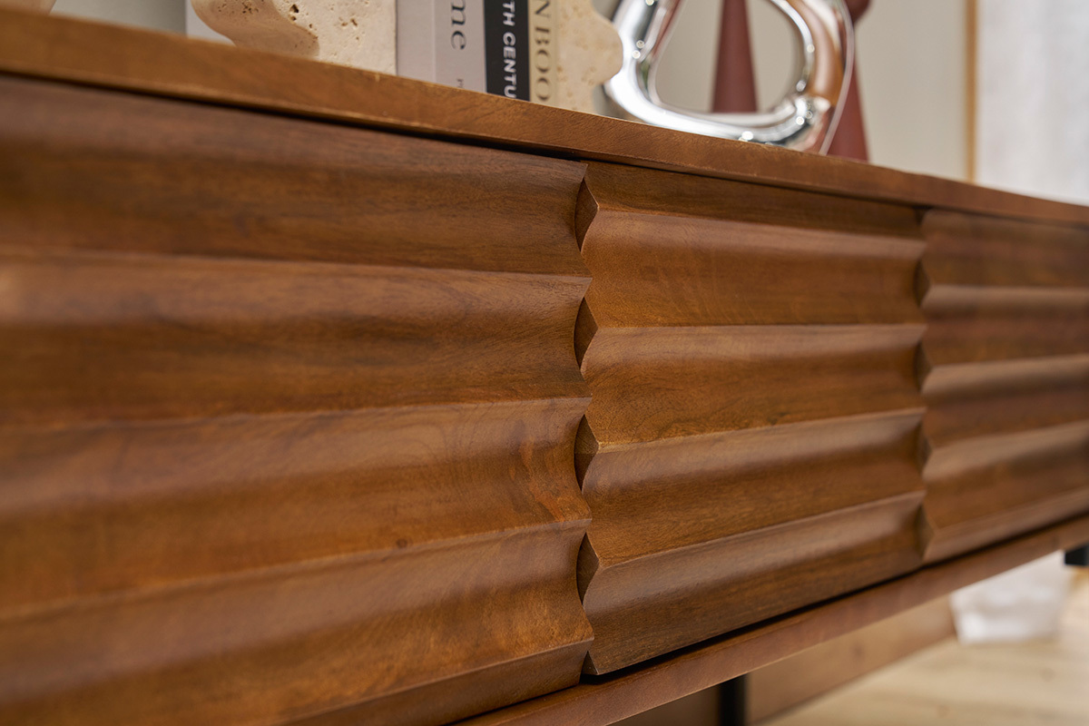 Primer plano del mueble para TV ONDA en madera de mango maciza con motivos tallados.