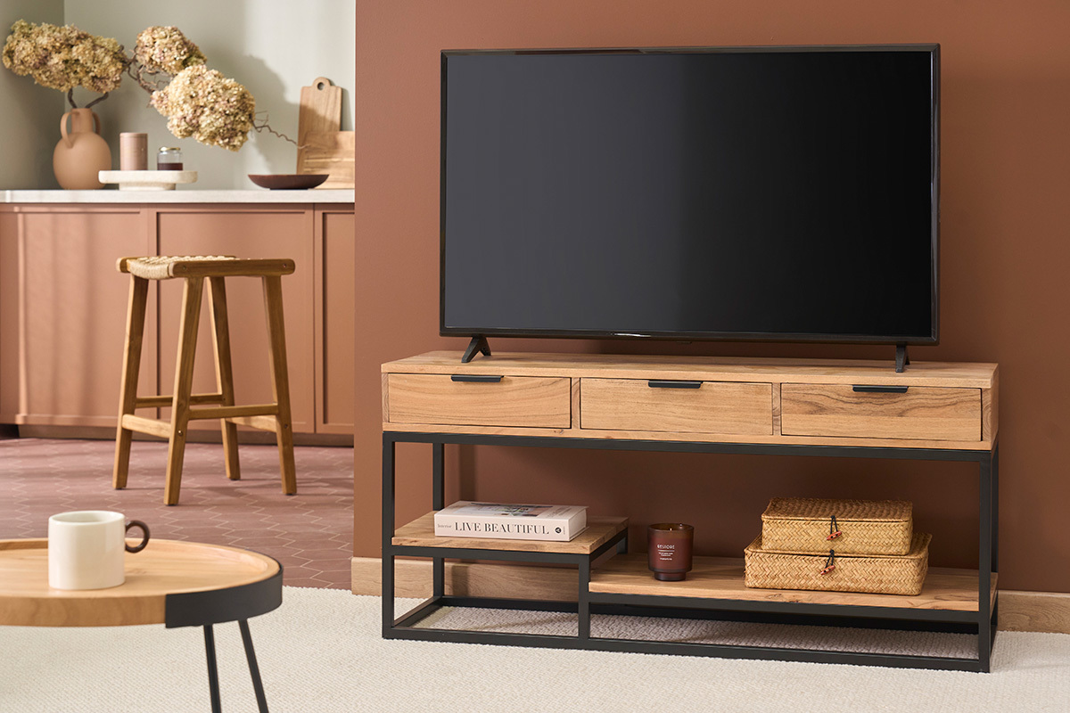 Mueble de TV de madera de acacia y metal negro con tres cajones y estantes, pantalla encima.