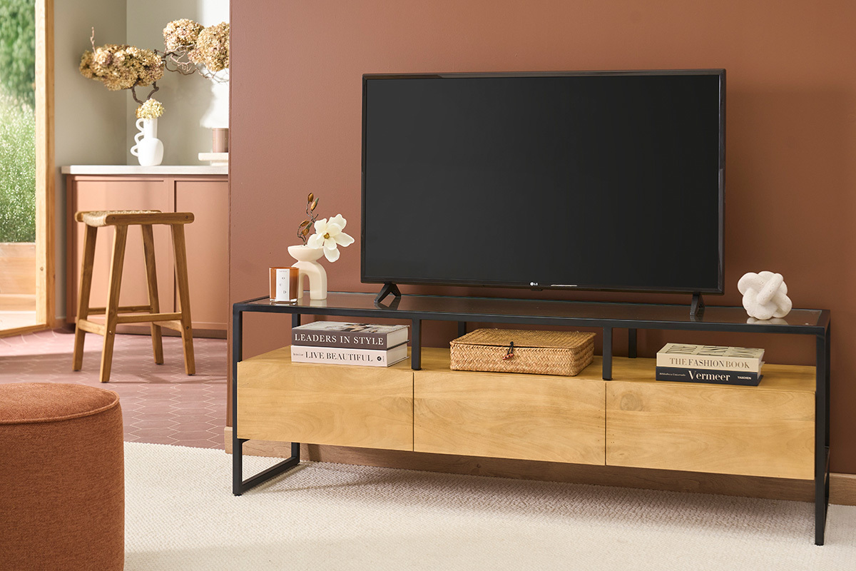 Mueble de TV DIYA en madera de mango, metal negro y vidrio con decoraci�n, vista frontal, con TV encima.
