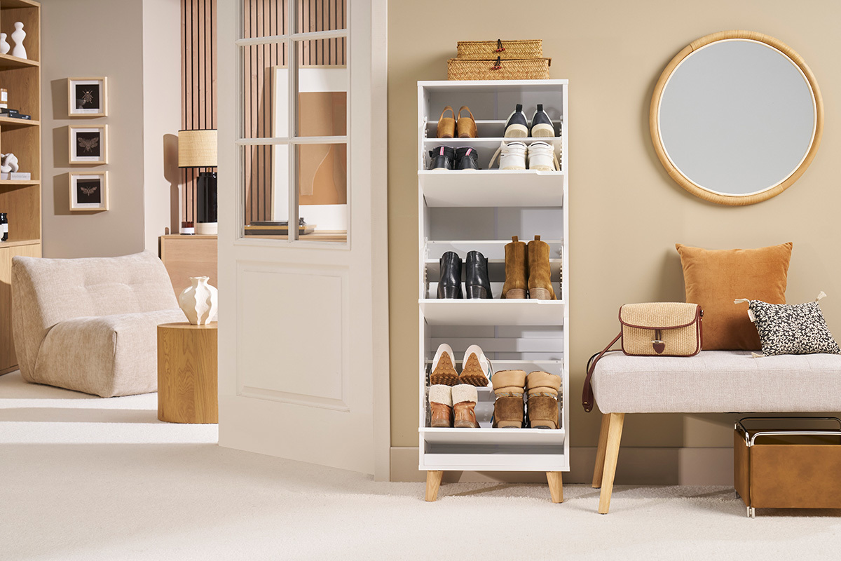 Mueble para zapatos blanco con 3 compartimentos y patas de roble, lleno de zapatos, en un interior moderno.