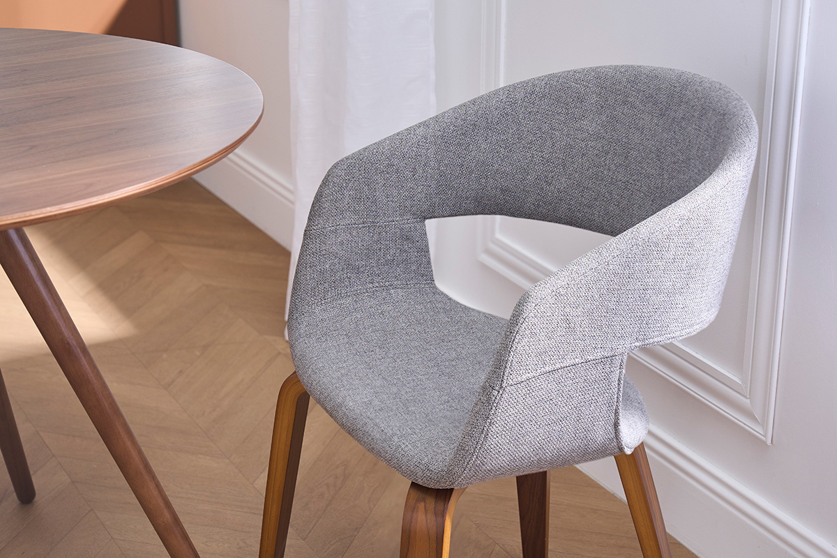 Silla de dise�o en tela gris con patas de madera oscura, vista de cerca.