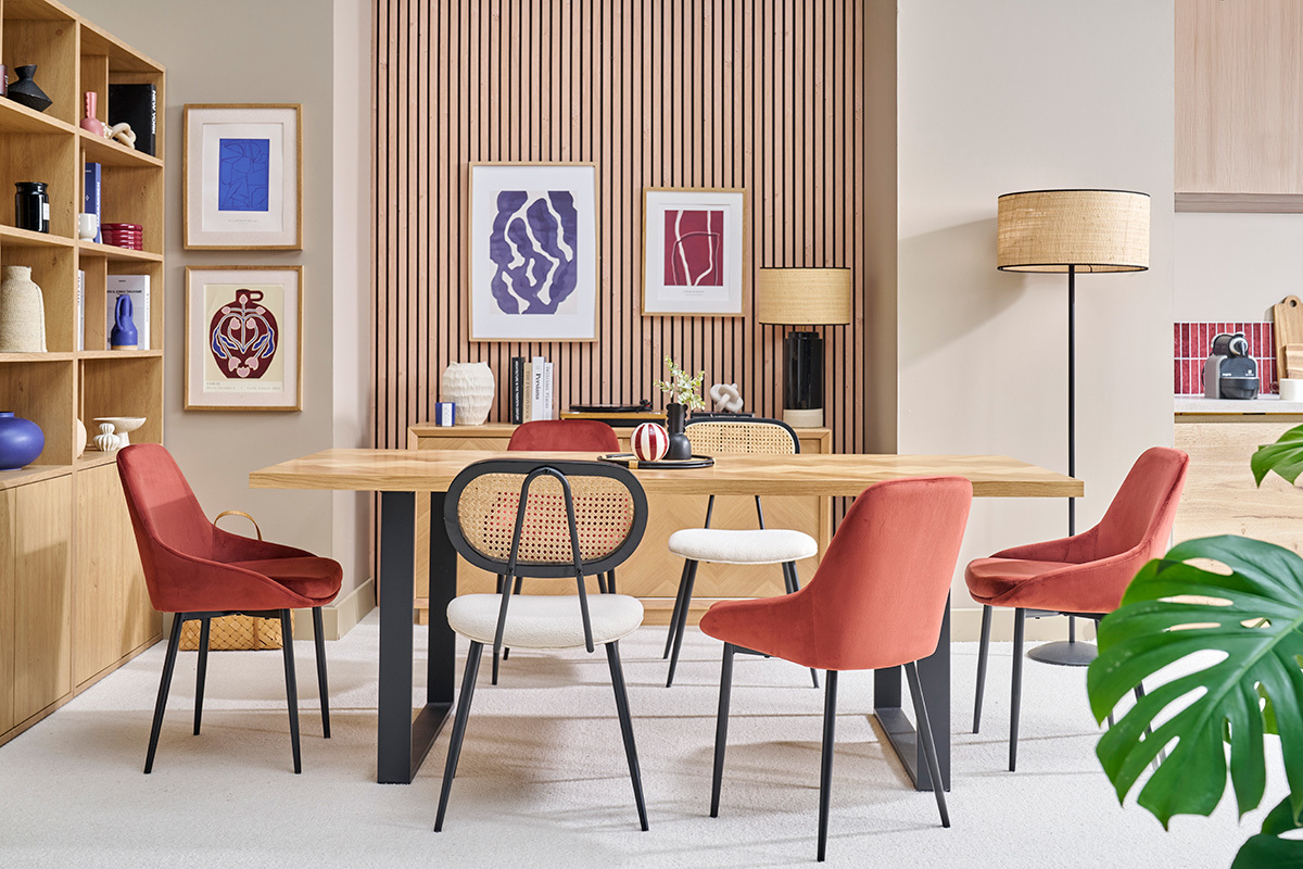 Comedor con sillas de terciopelo rojo y metal negro alrededor de una mesa de madera.