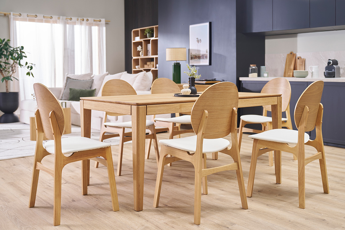 Sillas escandinavas de madera clara y blanca alrededor de una mesa, en un comedor moderno.