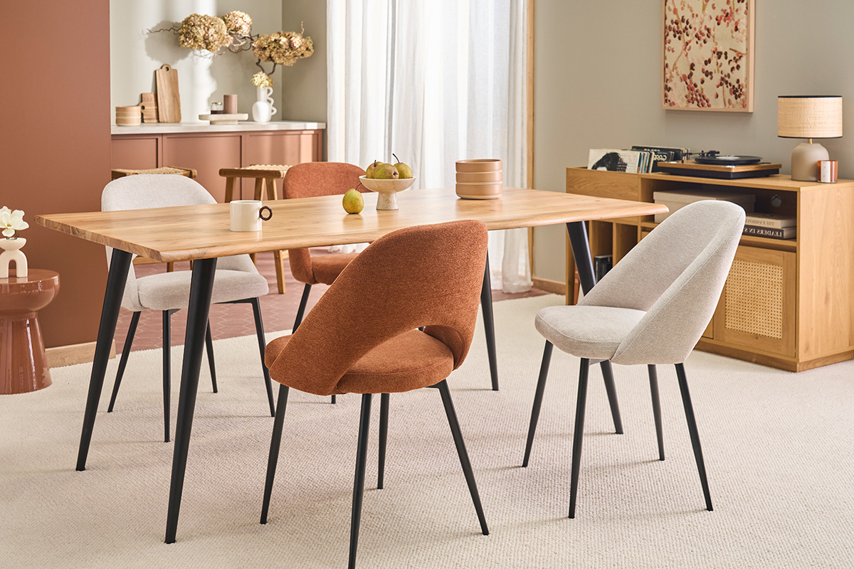 Sillas vintage COSETTE de tela color tierra quemada y metal negro alrededor de una mesa de madera.