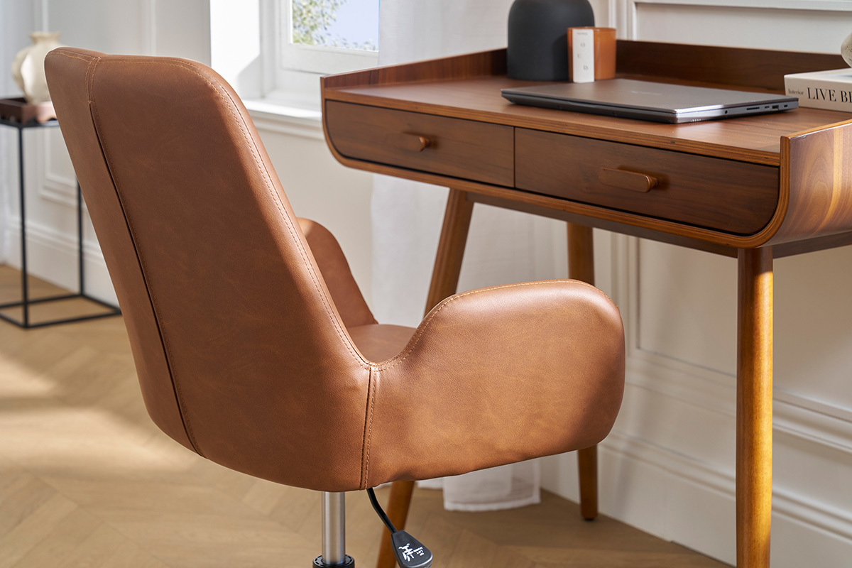 Silla de oficina marrn con ruedas vista de lado frente a un escritorio de madera.