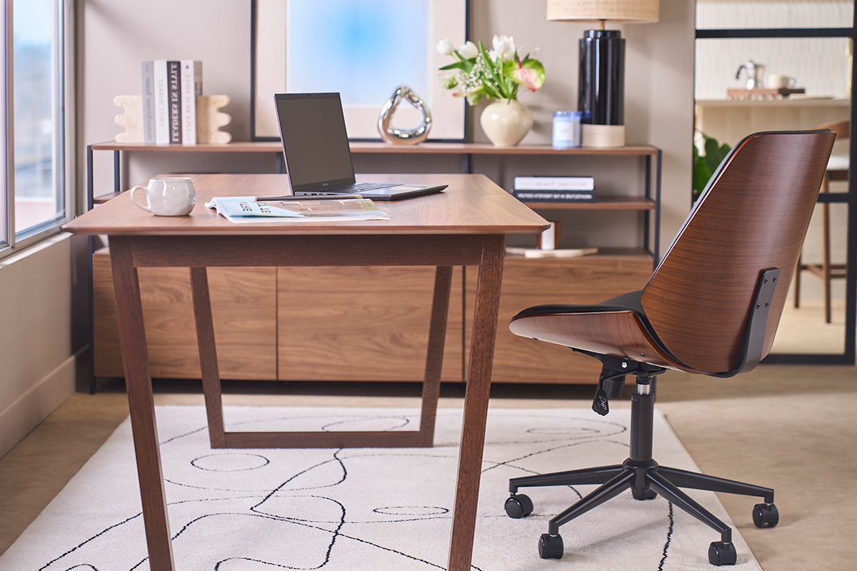 Silla de oficina DOUGLAS negra y madera oscura, vista de perfil, con escritorio de madera y port�til.