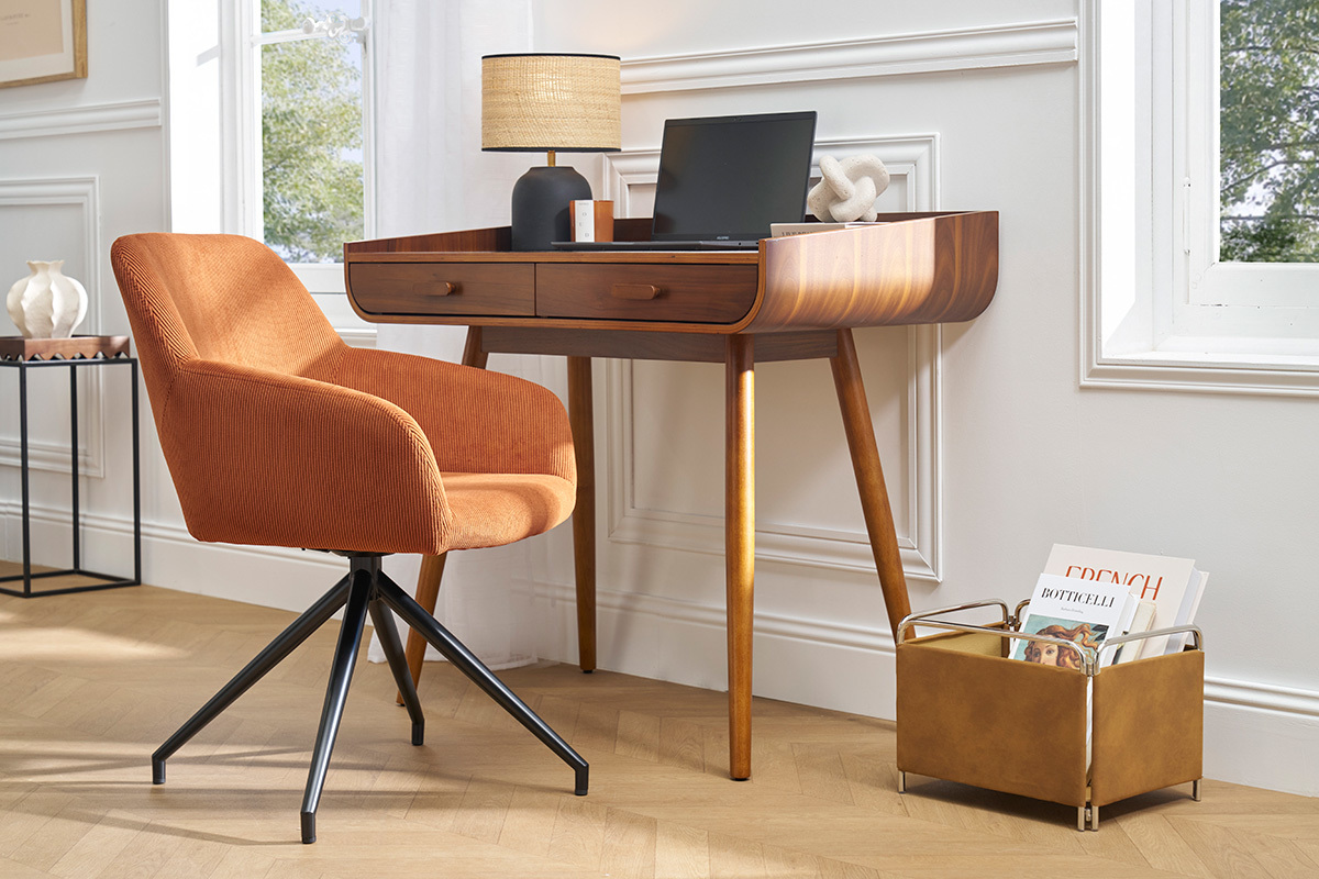 Silla giratoria de pana color tierra quemada con escritorio moderno de madera al lado.