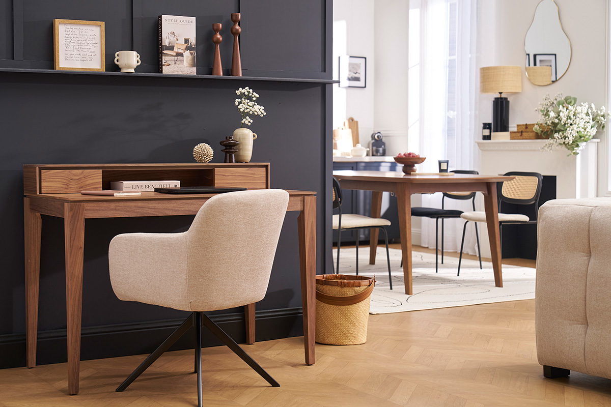 Silla giratoria 360� AMIKA en tejido beige, vista de perfil junto a un escritorio de madera