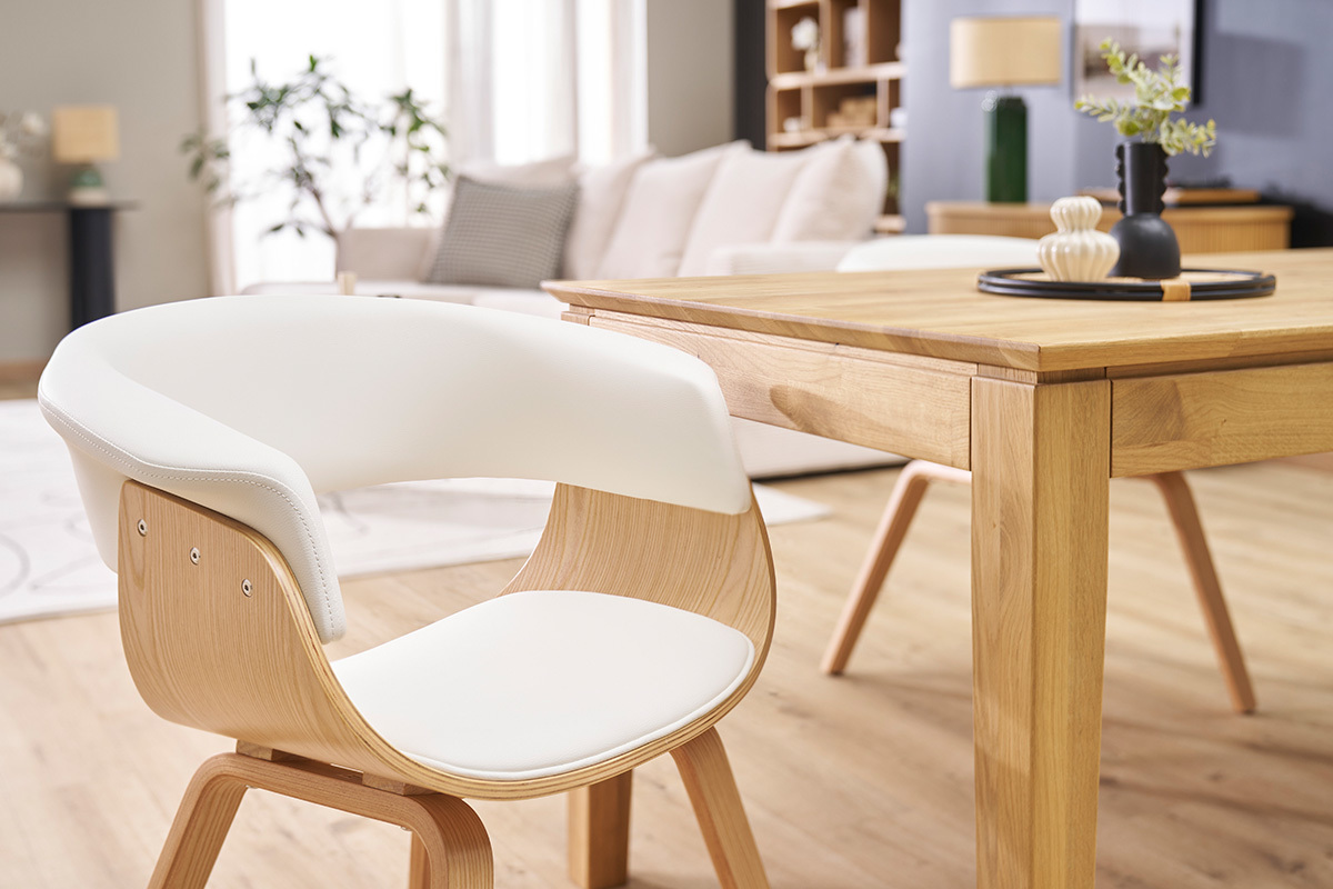Silla escandinava blanca y madera clara OKTAV vista de perfil al lado de una mesa de madera.