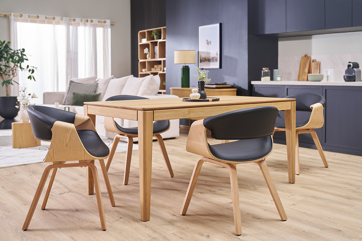 Sillas ARAMIS negras y de madera clara alrededor de una mesa de comedor en una sala de estar moderna.