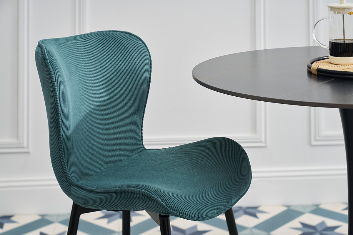 Silla de diseo en terciopelo acanalado azul petrleo con patas de metal negro, vista lateral.