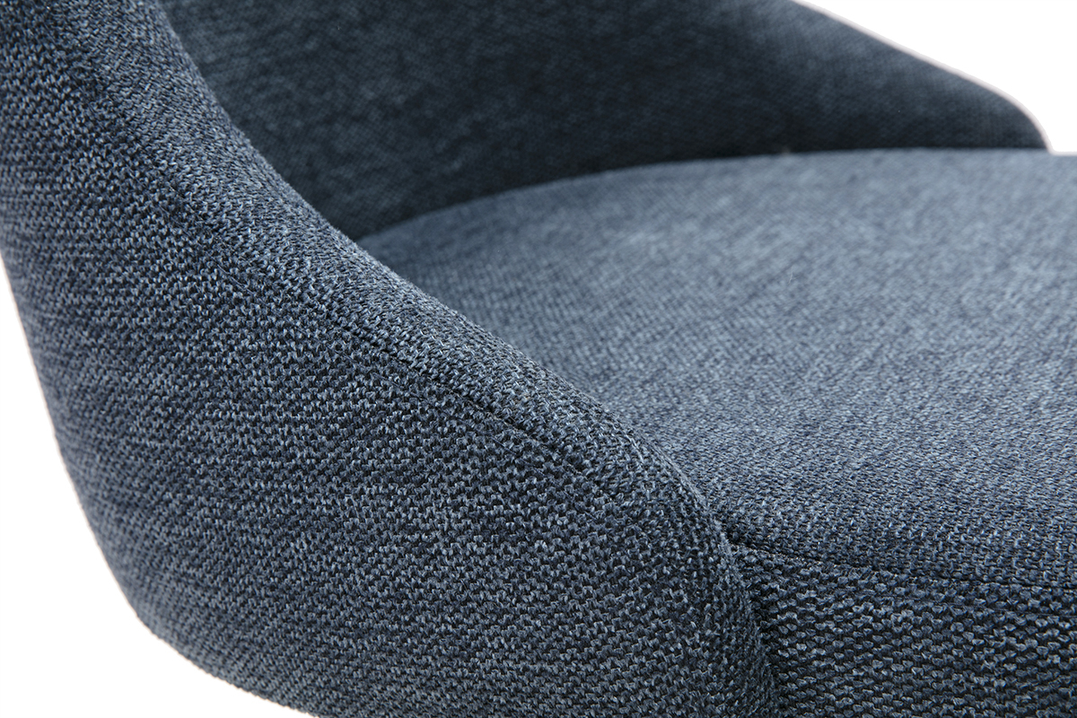 Detalle de una silla de dise�o en tejido con efecto terciopelo texturizado azul oscuro y base de metal negro.