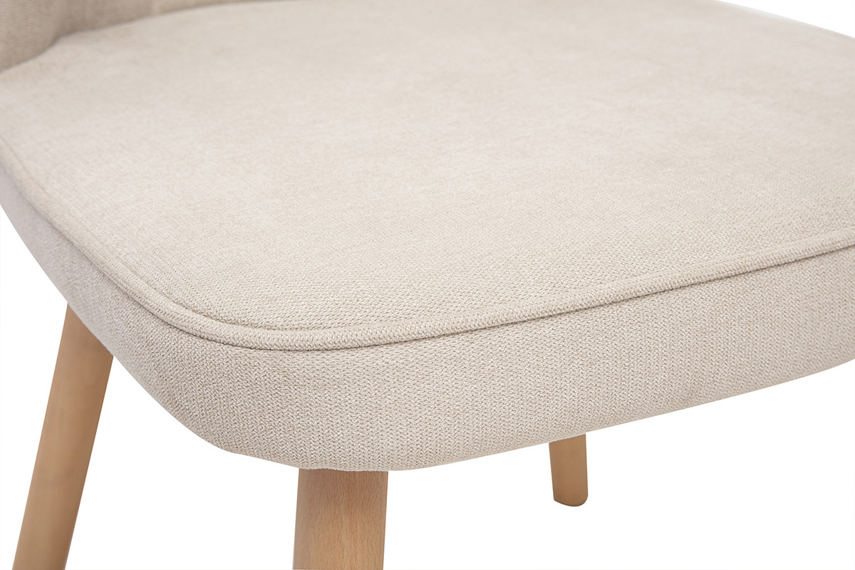 Primer plano del asiento de una silla de tela efecto terciopelo beige con patas de madera clara.